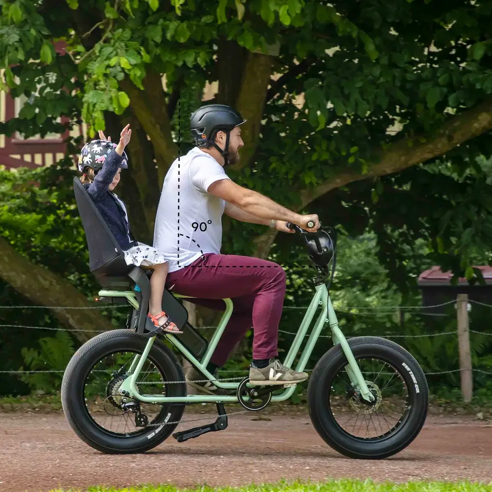 bild på en pappa med sin dotter bakom cykeln som visar komfortpositionen